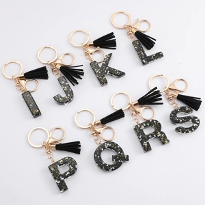 Black resin letter keychain with gold stars, velvet tassel and metal clasp for backpacks