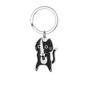 Detail shot of a cute cartoon black cat keychain holding a silver knife with enamel finish
