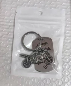 Detail of stainless steel motorcycle keychain with Spanish engraving in packaging