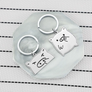 Funny cartoon pig stainless steel keychains on marble tray with striped background