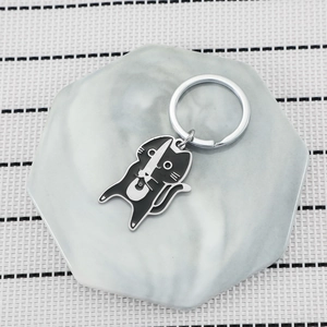 Minimalist black and white cat samurai keychain made of stainless steel on marble