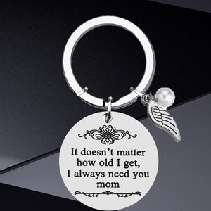 Macro shot of stainless steel keychain with engraved quote, feather charm and pearl