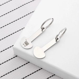 Dual stainless steel trolley token keychains with cart icon on a white stand