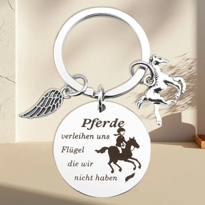 Detail of stainless steel equestrian keychain with German engraving and horse charms