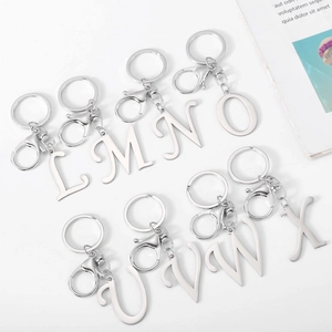 Polished stainless steel letter keychains L to X with silver lobster clasps on white