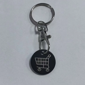 Detail of metal keychain with laser-engraved shopping cart icon on black round pendant