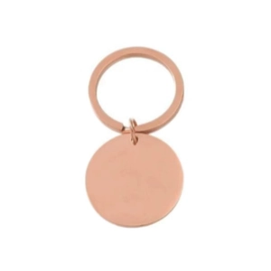 Close-up of a blank rose gold circular stainless steel keychain with a DIY metal pendant