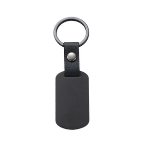 Minimalist black leather keychain with rectangular matte metal tag and silver rivet detail