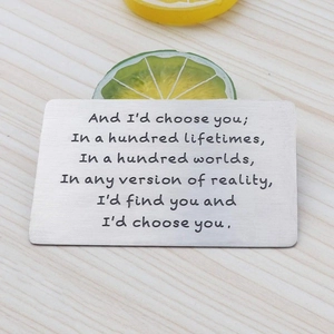 Close-up of engraved stainless steel wallet insert card on a rustic wood background
