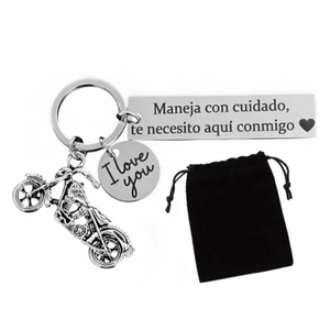 Macro detail of motorcycle keychain with Spanish engraving and black velvet pouch