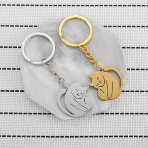 Minimalist cat shaped stainless steel keychains in gold and silver set on marble