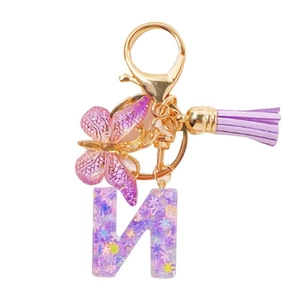 Porte-clés lettre M en résine pailletée violette avec breloque papillon et pompon violet