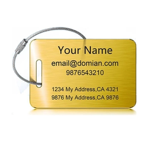 Macro shot of brushed gold luggage tag with stainless steel wire loop and ID engraving