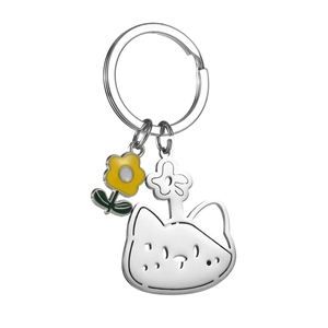 Détail d'un porte-clés chat argenté avec une fleur en émail jaune et métal poli brillant