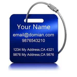 Detail of dark blue brushed metal luggage tag with wire cable and engraved text