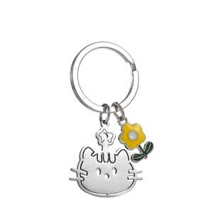 Détail du porte-clés chat en métal argenté avec pendentif fleur jaune et finition polie