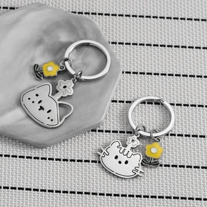 Porte-clés chat mignon en acier inoxydable avec charm fleur jaune sur fond de marbre
