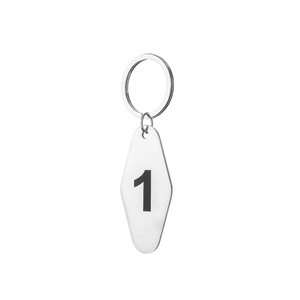 Close-up of diamond-shaped stainless steel keychain tag featuring a printed number 1