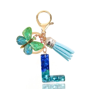 Close-up of blue sequin resin letter L keychain with butterfly and tassel detail