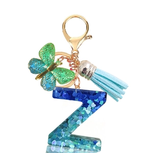 Detail of blue resin letter Z keychain with heart sequins, butterfly charm and blue tassel