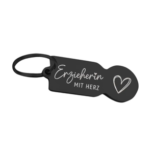 Close-up of black matte stainless steel shopping cart token with Erzieherin German text