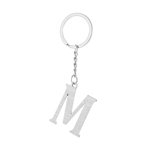 Macro detail of silver brushed metal letter M keychain with stainless steel ring