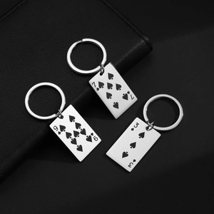 Detailed close-up of stainless steel playing card keychains with spades 9, 7, and 3