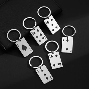 Detail of stainless steel poker Ace cards keychains with laser engraving on dark background