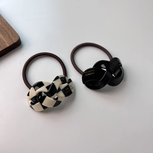Macro detail of the twisted acetate hair ring with checkered and black patterns