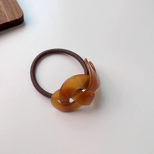 Detailed macro view of the tortoiseshell resin interlaced rings on an elastic hair tie