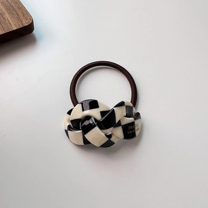 Close-up of checkered acetate hair tie with France Handmade text and elastic band