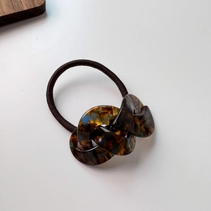 Macro detail of tortoiseshell acetate chain link hair tie with FRANCE Handmade engraving