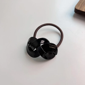 Brown high-elasticity hair tie with a black twisted acrylic link ornament on white background