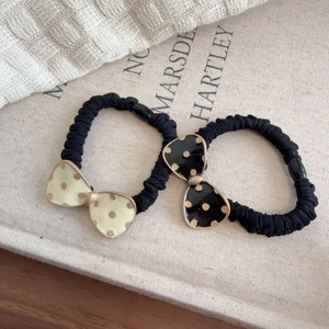 Detailed view of polka dot bow scrunchies with elegant gold-rimmed enamel finish