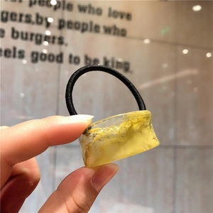 Elastic hair tie featuring creative yellow resin cylinder with artistic oil paint texture