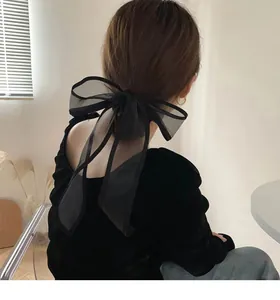 Close-up of oversized black organza bow hair clip featuring premium translucent mesh fabric