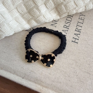Retro black scrunchie featuring a polka dot bow tie with elegant gold accents