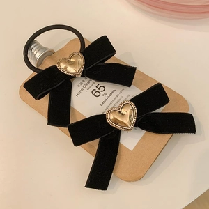 Détail de nœuds à cheveux en velours noir avec pendentifs cœurs dorés élégants