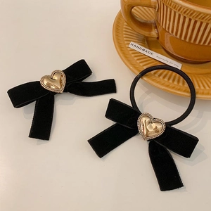 Détail d'un nœud papillon en velours noir et élastique avec cœur doré élégant