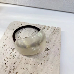 Detail of high-elasticity hair tie with a large pearlescent crescent resin ornament