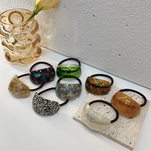 Close-up of 8-piece acetate elastic hair ties in leopard, amber, and marble textures