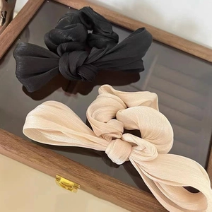 Elegant French satin bow hair scrunchies in black and champagne on wooden jewelry box