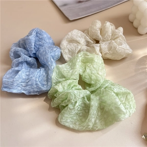 Détails des chouchous pastel bleu, vert et blanc avec texture gaufrée et motifs à pois