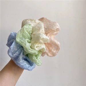 Gros plan de chouchous pastel avec texture à pois en bleu, vert, beige et orange clair