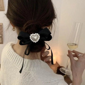 Elegant black satin bow hair tie with pearl heart and rhinestones on a female model