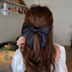 Elegant large black satin bow hair clip for women, perfect for ponytails and buns