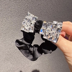 Chouchou élégant en soie noire avec un nœud étincelant orné de cristaux brillants
