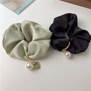 Close-up of satin scrunchies with white pearls and engraved I LOVE YOU gold heart charms