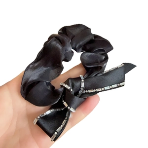 Elegant black silk scrunchie with rhinestone-studded bow hair accessory for women