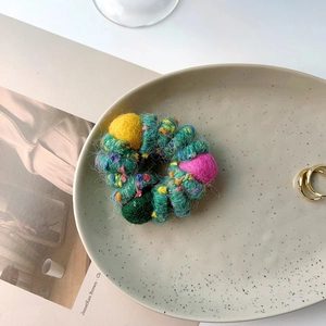 Winter plush telephone cord hair ring with colorful wool balls and green knit texture